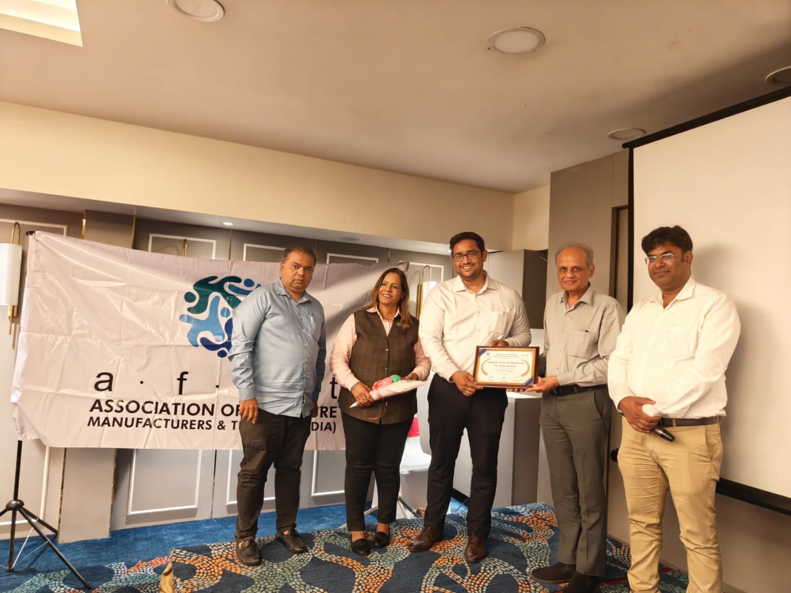Ankur Anand receiving a certificate of appreciation from AFMT